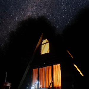 a house with a window and a starry sky at Alpinas de Sollipulli refugio sollipulli in Melipeuco
