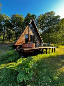 a small cabin with a deck in a field at Alpinas de Sollipulli refugio sollipulli in Melipeuco