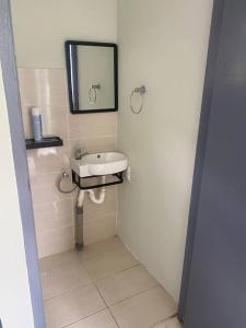 a bathroom with a sink and a mirror at Curacao Cozy Apartment in Willemstad