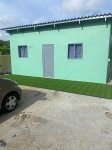 een blauw huis met een auto ervoor geparkeerd bij Curacao Cozy Apartment in Willemstad