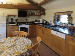 a kitchen with a table and a table and chairs at Blencathra in Mungrisdale