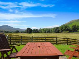 a picnic table with two chairs and a field at Blencathra in Mungrisdale
