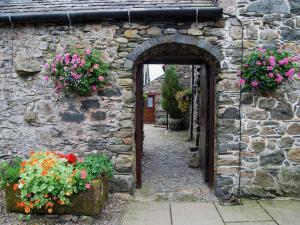 an entrance to a stone building with two potted flowers at Blencathra in Mungrisdale