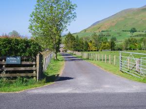 a road with a fence on the side of a hill at Blencathra in Mungrisdale