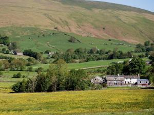 a house in the middle of a field with a hill at Blencathra in Mungrisdale