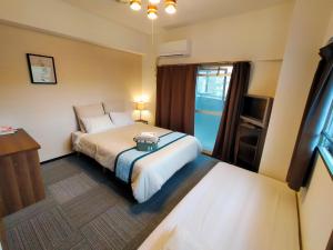 a hotel room with a bed and a television at Coco Fukuoka Chiyo in Fukuoka