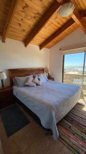 - une chambre avec un grand lit et une grande fenêtre dans l'établissement Casa Linda vista, à Curanipe