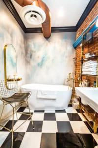 ein Badezimmer mit einer weißen Badewanne und einem karierten Boden in der Unterkunft Luxury 2 BR 2 Bath Downtown Paducah Condo in Paducah