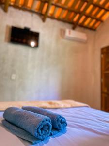 two towels are sitting on top of a bed at Pousada Flor de Laranjeira in Goiás