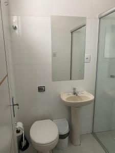 a bathroom with a sink and a toilet and a mirror at HOTEL LIFE IJUI in Ijuí