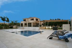 a house with a swimming pool and a house at Villa Leonidas in Protaras