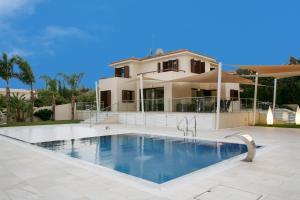 a house with a swimming pool in front of a house at Villa Leonidas in Protaras