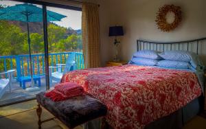 a bedroom with a bed with a view of a balcony at Rio Sierra Riverhouse in Three Rivers