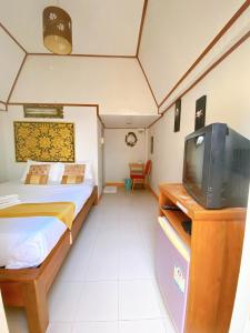 a small bedroom with a bed and a tv at Sila Resort Sukhothai in Sukhothai