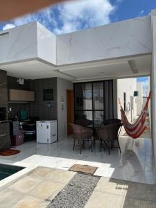 eine große weiße Terrasse mit einem Tisch und Stühlen in der Unterkunft Casa da Praia Carapibus in Conde