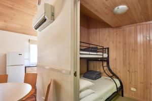 ein kleines Zimmer mit einem Etagenbett und einem Tisch in der Unterkunft NRMA Bathurst Panorama Holiday Park in Bathurst