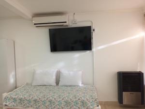a room with a bed and a tv on the wall at Bethel Alojamiento in Zapala