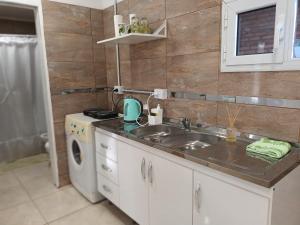 a kitchen with a sink and a washing machine at Bethel Alojamiento in Zapala