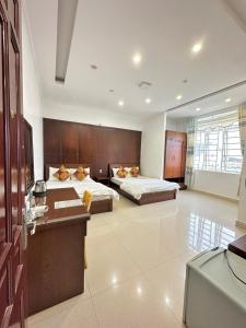 una camera d'albergo con 2 letti e una scrivania di Hoàng Anh hotel a Ðưc Trọng