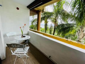einen Tisch und zwei Stühle in einem Zimmer mit Fenster in der Unterkunft Tunui City Apartment - Quiet & Pool in Papeete