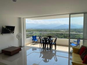 sala de estar con mesa, sillas y ventana grande en Alojamiento Santa Fe antioquia, en Santa Fe de Antioquia