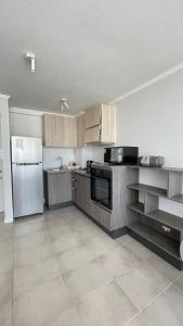 een keuken met houten kasten en roestvrijstalen apparatuur bij I A pasos de la playa y del centro in La Serena +6 foto's