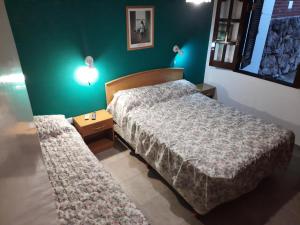 a bedroom with a bed and a nightstand with a bed sidx sidx at Cabaña El Hornero in Mina Clavero
