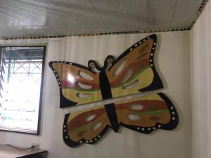 a butterfly decoration on the wall of a room at Unu Pikin Guesthouse in Paramaribo