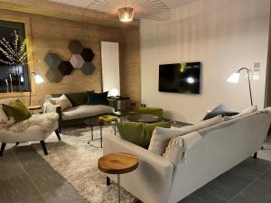 ein Wohnzimmer mit Sofas und Stühlen und einem Fernseher in der Unterkunft Appartement standing 100m², pied des pistes, 8 pers, terrasse, WiFi, parking - FR-1-598-43 in Les Gets