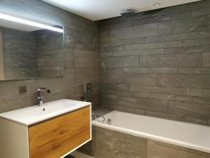 ein Badezimmer mit Waschbecken und Badewanne in der Unterkunft Appartement standing 100m², pied des pistes, 8 pers, terrasse, WiFi, parking - FR-1-598-43 in Les Gets + 9 Fotos
