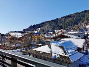 eine Stadt mit schneebedeckten Dächern und einem Berg in der Unterkunft Appartement standing 100m², pied des pistes, 8 pers, terrasse, WiFi, parking - FR-1-598-43 in Les Gets