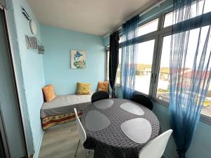 una stanza con un tavolo, un letto e una finestra di PORT-VENDRES - Appartement T2 avec parking, 4 pers, animaux admis - FR-1-309-266 a Port-Vendres