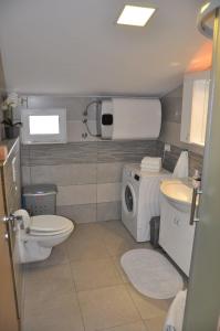 een badkamer met een toilet, een wastafel en een wasmachine bij Apartment Doni in Split