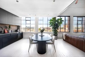 uma cozinha e sala de jantar com mesa e cadeiras em New York Converted Warehouse Apartment in Richmond em Melbourne