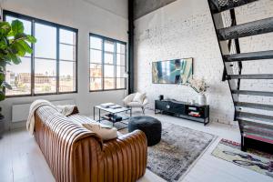 a living room with a couch and a tv at New York Converted Warehouse Apartment in Richmond in Melbourne