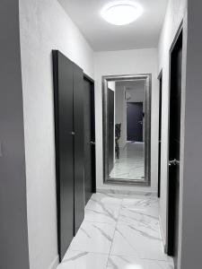 a hallway with two black doors and a mirror at Hermoso Departamento Entero Planta Baja in Acapulco