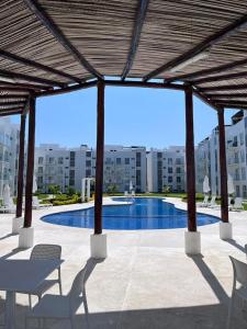 a patio with chairs and a swimming pool in a building at Hermoso Departamento Entero Planta Baja in Acapulco