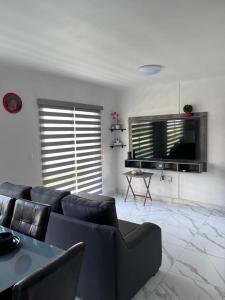 a living room with a couch and a flat screen tv at Hermoso Departamento Entero Planta Baja in Acapulco +13 photos