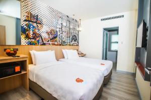 Go Hotels Plus Naga في نجا: غرفة فندقية بسريرين ولوحة على الحائط