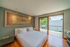 a bedroom with a large bed and a large window at Villa Rio - Contemporary 2BR Villa in Downtown Seminyak in Seminyak