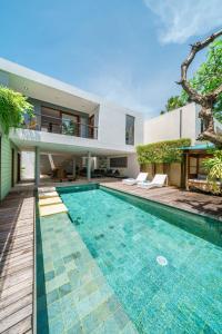 a swimming pool in front of a house at Villa Rio - Contemporary 2BR Villa in Downtown Seminyak in Seminyak