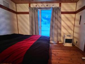 1 dormitorio con 1 cama y puerta con ventana en AnYa Ski in & Ski out at Pippu Hokkaido Max 6 ppl en Pippu