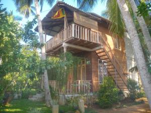 a house with a flag on the front of it at Coconut Island Yala in Tissamaharama