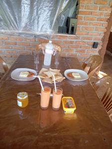 a wooden table with plates of food and a bottle of water at Coconut Island Yala in Tissamaharama +37 photos