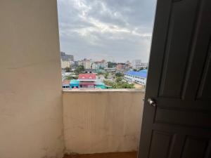 an open door to a balcony with a view of a city at Rooftop room in We Residence in Pattaya