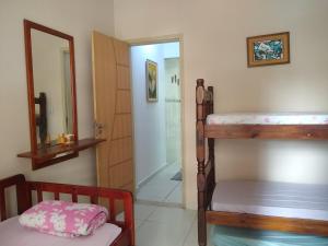 a bedroom with a bunk bed and a bathroom at Apartamento de temporada no canto do forte ! in Praia Grande