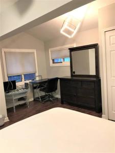 Zimmer mit einem Schreibtisch und einer Kommode mit einem Spiegel in der Unterkunft 2BR Lake House 40ft Dock Access in Keego Harbor