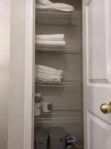 a closet with white towels and two baskets at Elegant 4 bedroom house with community pool & deck in Germantown