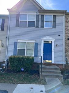 a blue house with a blue door and stairs at Elegant 4 bedroom house with community pool & deck in Germantown