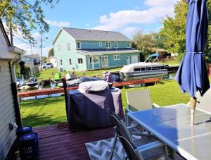 a patio with a table and chairs on a deck at 2BR Lake House 40ft Dock Access in Keego Harbor